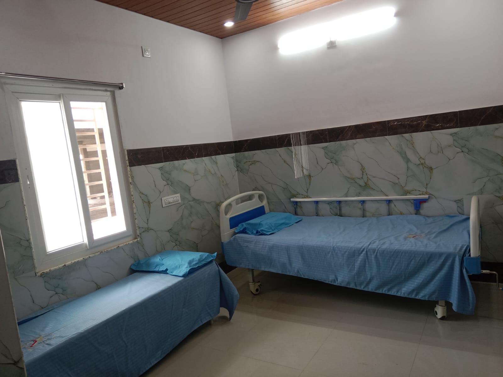 Hospital patient room with blue beds in Yeleswaram